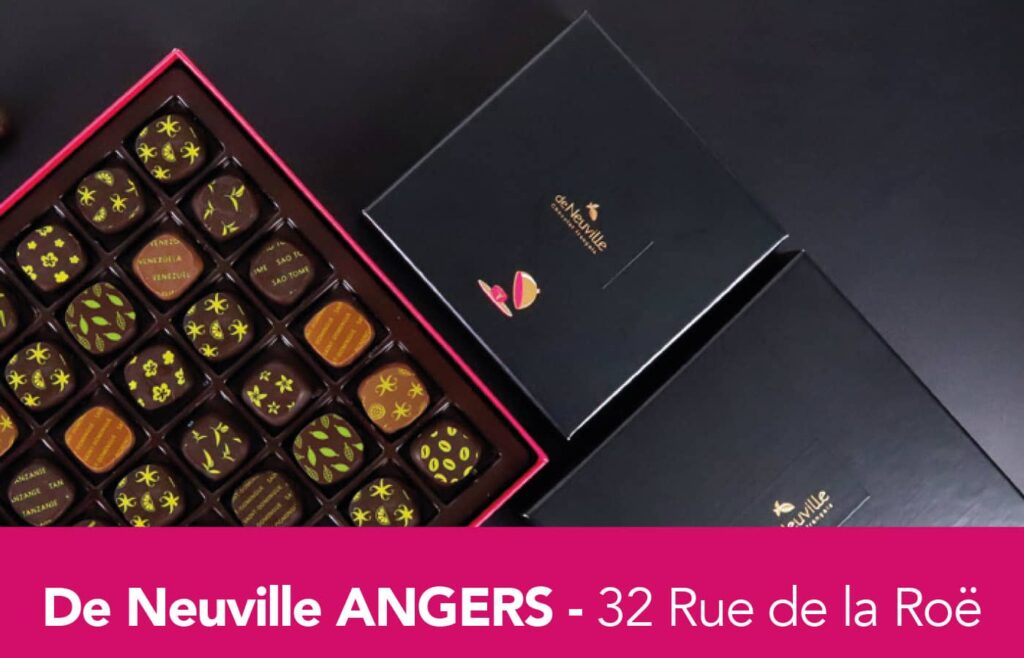 Boite de chocolats ouverte, avec deux autres boites noire fermées, sur fond noir, de la marque Deneuville.